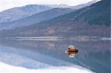 Flat calm Loch Levan with reflections of snow-capped mountains and small red fishing boat, Glencoe Village, near Fort William, Highland, Scotland, United Kingdom, Europe Foto de stock - Sin royalties Premium, Código: 6119-08266460