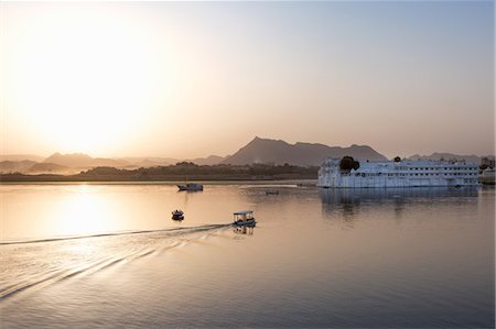 Boat going out to Lake Palace Hotel at dusk, the hotel is situated in the middle of Lake Pichola, in Udaipur, Rajasthan, India, Asia Stock Photo - Premium Royalty-Free, Code: 6119-08568429