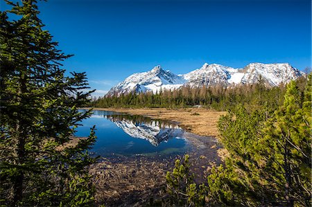 Snowy Corno Di Braccia is reflected in Lake Entova, Province of Sondrio, Malenco Valley, Valtellina, Lombardy, Italy, Europe Stock Photo - Premium Royalty-Free, Code: 6119-08518047