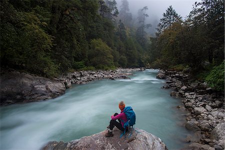 simsearch:6119-08797333,k - A woman takes a break from the trail and sits beside the Langtang Khola near the little village of Riverside on a misty evening, Nepal, Himalayas, Asia Stockbilder - Premium RF Lizenzfrei, Bildnummer: 6119-08797346