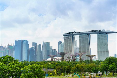 View over the Gardens by the Bay to the three towers of the Marina Bay Sands Hotel and city skyline beyond, Singapore, Southeast Asia, Asia Foto de stock - Royalty Free Premium, Número: 6119-08725029