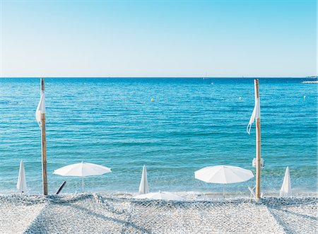 Giant white beach umbrella next to the ocean against a blue sky in Juan les Pins, Cote d'Azur, Provence, France, Mediterranean, Europe Stock Photo - Premium Royalty-Free, Code: 6119-09054140