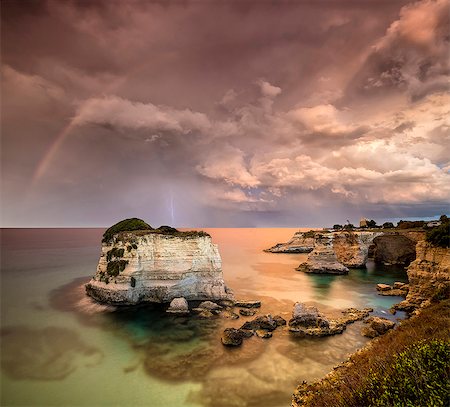 simsearch:6119-09238917,k - Rainbow and lightning after the storm on cliffs known as Faraglioni di Sant'Andrea, province of Lecce, Apulia, Italy, Europe Foto de stock - Sin royalties Premium, Código: 6119-09073972