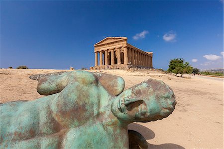 Bronze statue of the fallen Icarus frames the ancient Temple of Concordia, Valle dei Templi, Agrigento, UNESCO World Heritage Site, Sicily, Italy, Europe Stock Photo - Premium Royalty-Free, Code: 6119-09073981