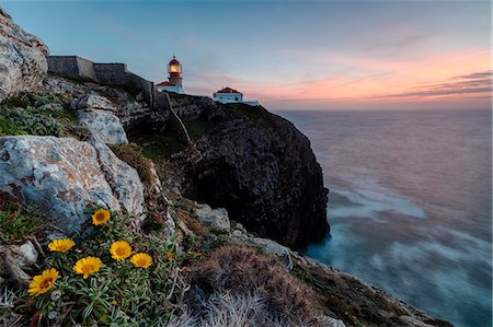 Pink sky at sunset and yellow flowers frame the lighthouse, Cabo De Sao Vicente, Sagres, Algarve, Portugal, Europe Stock Photo - Premium Royalty-Free, Code: 6119-09074040