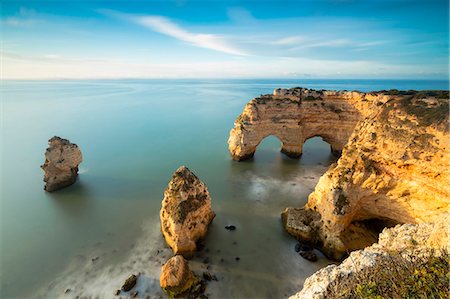 Sunrise on cliffs framed by turquoise water of the ocean, Praia da Marinha, Caramujeira, Lagoa Municipality, Algarve, Portugal, Europe Stock Photo - Premium Royalty-Free, Code: 6119-09074042