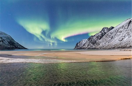 senja - Green lights of Northern Lights (aurora borealis) reflected in the cold sea surrounded by snowy peaks, Ersfjord, Senja, Troms, Norway, Scandinavia, Europe Stock Photo - Premium Royalty-Free, Code: 6119-09074076