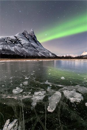 Ice bubbles of frozen sea and the snowy peak of Otertinden under the Northern Lights (aurora borealis), Oteren, Lyngen Alps, Troms, Norway, Scandinavia, Europe Foto de stock - Sin royalties Premium, Código: 6119-09074084