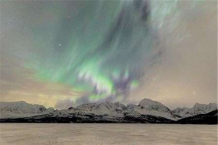 The icy lake of Jaegervatnet framed by the Northern Lights (aurora borealis) and starry sky in the polar night, Lyngen Alps, Troms, Norway, Scandinavia, Europe Stock Photo - Premium Royalty-Free, Code: 6119-09074088