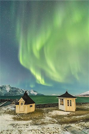 The Northern Lights (aurora borealis) and stars illuminate the wooden huts by icy sea, Djupvik, Lyngen Alps, Troms, Norway, Scandinavia, Europe Foto de stock - Sin royalties Premium, Código: 6119-09074089