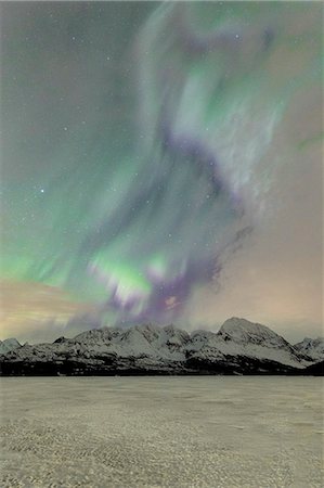 The icy lake of Jaegervatnet framed by the Northern Lights (aurora borealis) and starry sky in the polar night, Lyngen Alps, Troms, Norway, Scandinavia, Europe Photographie de stock - Premium Libres de Droits, Code: 6119-09074091