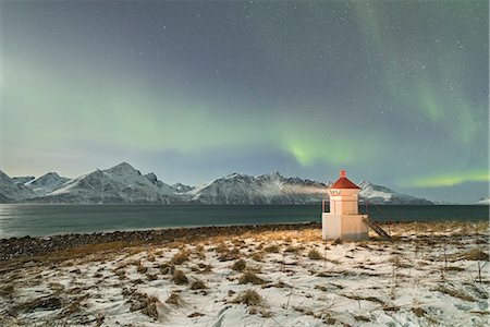 The Northern Lights (aurora borealis) and stars illuminate the lighthouse framed by icy sea, Djupvik, Lyngen Alps, Troms, Norway, Scandinavia, Europe Stock Photo - Premium Royalty-Free, Code: 6119-09074092