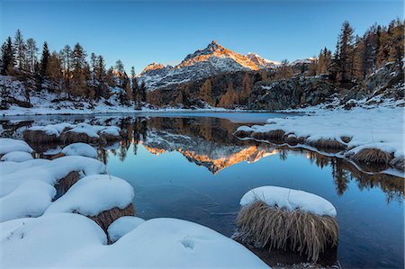 province of sondrio - The rocky peak reflected in the frozen Lake Mufule at dawn, Malenco Valley, Province of Sondrio, Valtellina, Lombardy, Italy, Europe Photographie de stock - Premium Libres de Droits, Code: 6119-09074020