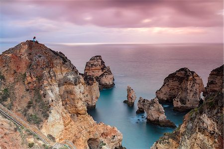 simsearch:6119-09073972,k - Photographer on top of cliffs surrounded by sea under the pink sky at sunrise, Ponta Da Piedade, Lagos, Algarve, Portugal, Europe Stock Photo - Premium Royalty-Free, Code: 6119-09074039