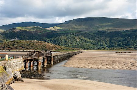 Barmouth Bridge (Viaduct), largely wooden construction, on Cambrian Coast Railway across River Mawddach, Cardigan Bay, Gwynedd, Wales, United Kingdom, Europe Stock Photo - Premium Royalty-Free, Code: 6119-09085675