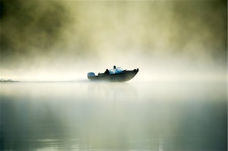 A motorboat navigates the fog on a Minnesota Lake during an early morning, Minnesota, United States of America, North America Photographie de stock - Premium Libres de Droits, Code: 6119-09161865