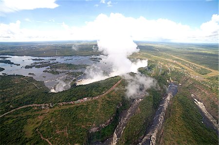 Mist rises above the Victoria Falls waterfall (Mosi-oa-Tunya), UNESCO World Heritage Site on the border of Zimbabwe and Zambia, Africa Foto de stock - Sin royalties Premium, Código: 6119-09170291