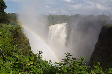 A rainbow in spray by the Victoria Falls waterfall (Mosi-oa-Tunya), UNESCO World Heritage Site, on the border of Zimbabwe and Zambia, Africa Foto de stock - Sin royalties Premium, Código: 6119-09170294