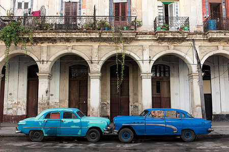 simsearch:841-07081805,k - Two blue cars face nose to nose outside a dilapidated building, Havana, Cuba, West Indies, Caribbean, Central America Photographie de stock - Premium Libres de Droits, Code: 6119-09182782