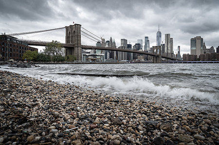 simsearch:841-09086033,k - A pebble beach on the East River in Brooklyn looking towards the Brooklyn Bridge and Lower Manhattan, New York, United States of America, North America Stock Photo - Premium Royalty-Free, Code: 6119-09253300