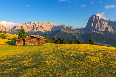 Last rays of sun on traditional hut with view on Sassolungo and Sella Group, Gardena Valley, South Tyrol, Dolomites, Italy, Europe Stock Photo - Premium Royalty-Free, Code: 6119-09228765