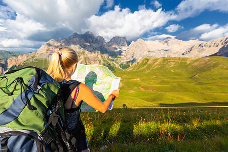 famous people reading - Hiker reading map with Marmolada in the background, San Nicolo Pass, Fassa Valley, Trentino, Dolomites, Italy, Europe Foto de stock - Sin royalties Premium, Código: 6119-09228779