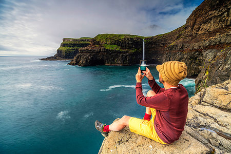 simsearch:6119-09238919,k - Man with smartphone snaps photos at Gasadalur waterfall, Vagar island, Faroe Islands, Denmark, Europe Photographie de stock - Premium Libres de Droits, Code: 6119-09238660