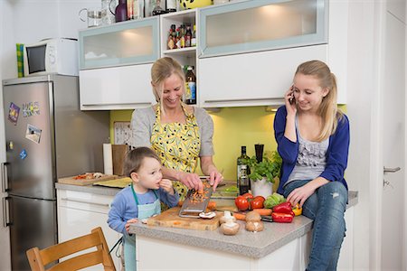 rape - Mother and son grating vegetables while daughter talking on phone Photographie de stock - Premium Libres de Droits, Code: 6121-07740177