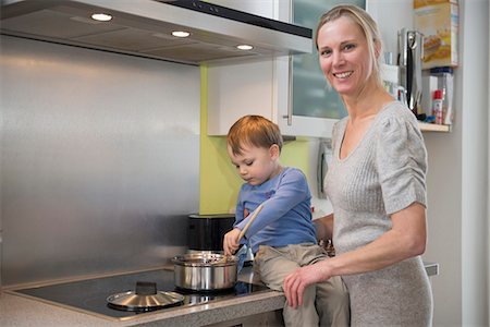 Boy helping his mother stirring food in pot, smiling Photographie de stock - Premium Libres de Droits, Code: 6121-07740183