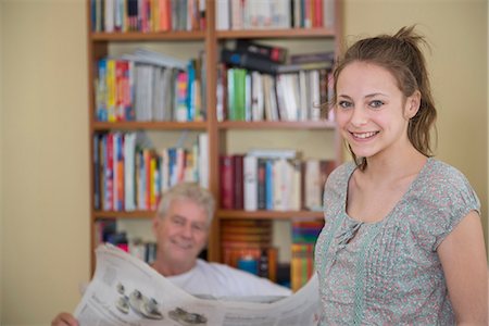 Portrait of grandfather and granddaughter with newspaper on couch in living room, smiling Foto de stock - Sin royalties Premium, Código: 6121-07740280