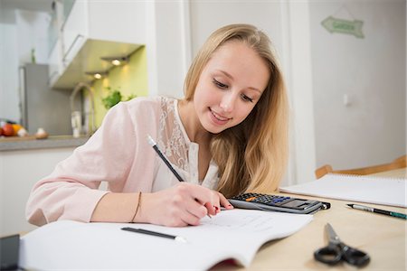 Teenage girl doing homework, smiling Photographie de stock - Premium Libres de Droits, Code: 6121-07740238