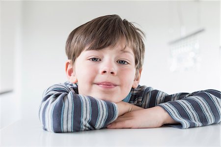 solo varones - Portrait of boy leaning on table, close up Foto de stock - Sin royalties Premium, Código: 6121-07740357