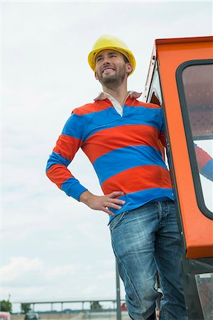 Construction worker on site with excavator Stock Photo - Premium Royalty-Free, Code: 6121-07740335