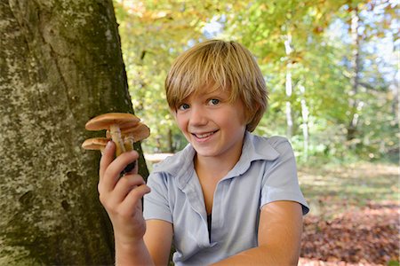 Boy holding mushroom, smiling, portrait, Bavaria, Germany Foto de stock - Sin royalties Premium, Código: 6121-07740547