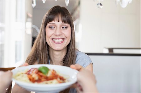 spaghetti - Portrait of woman with spaghetti plate, smiling Stock Photo - Premium Royalty-Free, Code: 6121-07740755