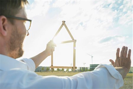 Man at development area holding model house Stockbilder - Premium RF Lizenzfrei, Bildnummer: 6121-07740781