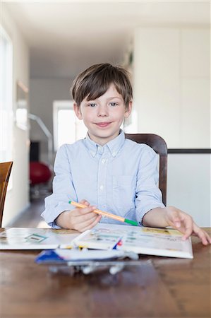 Portrait of boy doing his homework, smiling Photographie de stock - Premium Libres de Droits, Code: 6121-07740926