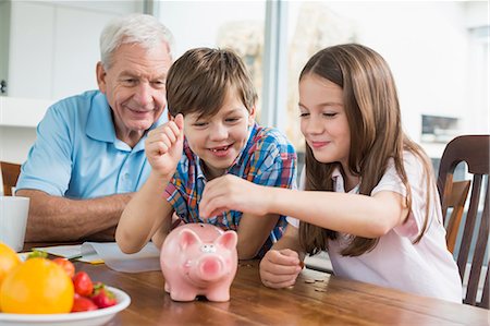 Two children and grandfather with piggy bank Photographie de stock - Premium Libres de Droits, Code: 6121-07741059