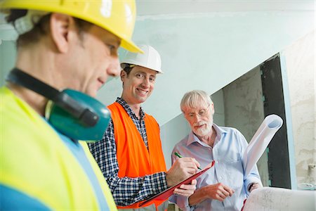 Architect and two construction workers at construction site of new building Stock Photo - Premium Royalty-Free, Code: 6121-07741238