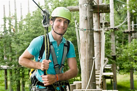 Portrait of young man climbing crag, smiling Stock Photo - Premium Royalty-Free, Code: 6121-07741981