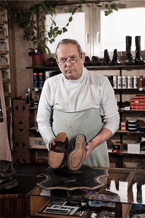 Cobbler in store holding pair of leather shoes Photographie de stock - Premium Libres de Droits, Code: 6121-07741917