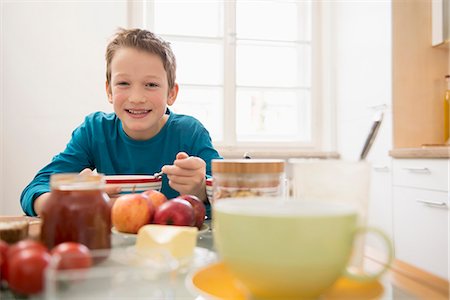 Boy having breakfast in kitchen Foto de stock - Sin royalties Premium, Código: 6121-07809640