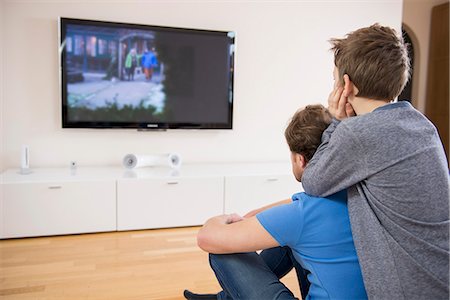 Father and son watching TV at home Photographie de stock - Premium Libres de Droits, Code: 6121-07809661
