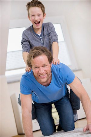 piggyback ride - Playful father and son at home Stock Photo - Premium Royalty-Free, Code: 6121-07809678