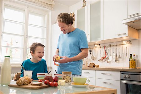 pyjamas (sleepwear with pants) - Father peeling apple for son at breakfast table Stock Photo - Premium Royalty-Free, Code: 6121-07809629