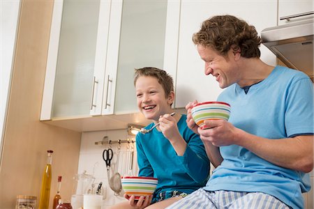 Father and son eating muesli in kitchen Foto de stock - Sin royalties Premium, Código: 6121-07809633