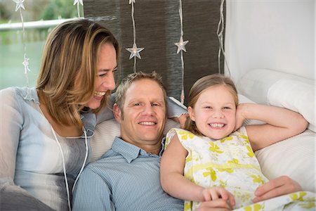 parent - Parents with daughter sitting on couch having fun Stock Photo - Premium Royalty-Free, Code: 6121-07809721