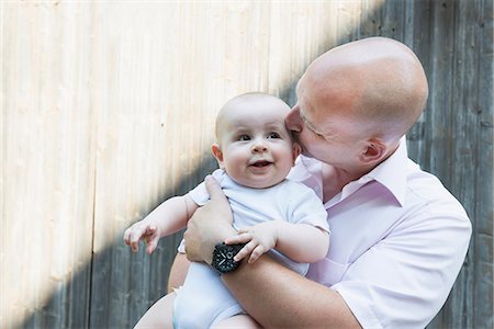 small - Father kissing holding baby son proud smiling Stock Photo - Premium Royalty-Free, Code: 6121-07809839