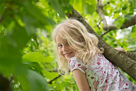 Young blonde girl in garden climbing tree Foto de stock - Sin royalties Premium, Código: 6121-07809951