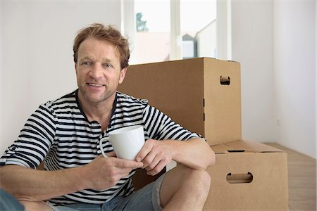 Man drinking coffee sitting floor new apartment Stock Photo - Premium Royalty-Free, Code: 6121-07809964